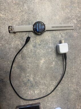 Round Smartwatch in Light Gray and Silver with Charging Cable